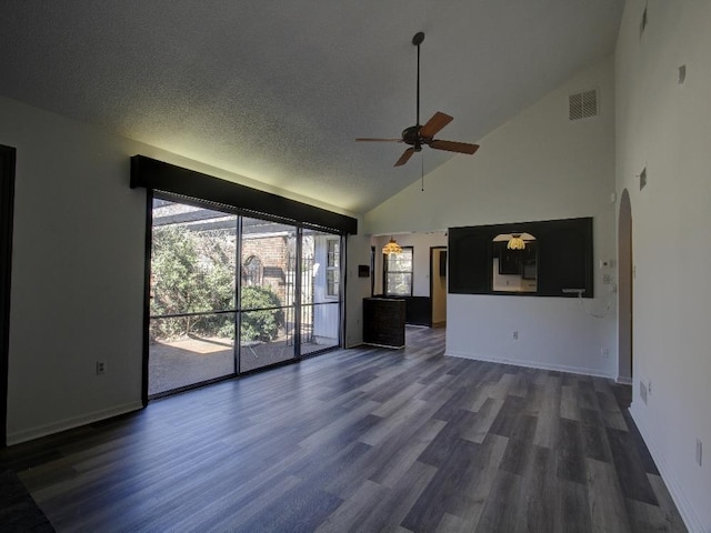 unfurnished living room with a ceiling fan, visible vents, arched walkways, and dark wood finished floors