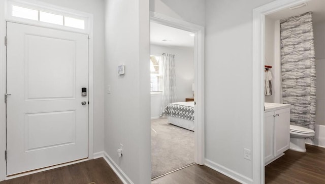 foyer featuring baseboards and dark wood-type flooring