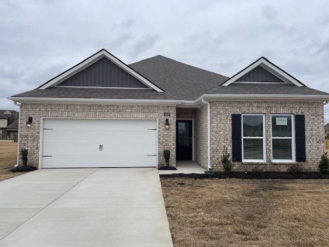 view of front of property with a garage, a front lawn, concrete driveway, and brick siding