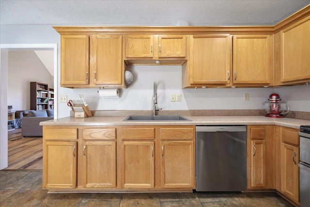 kitchen featuring a sink, a textured ceiling, light countertops, and dishwasher