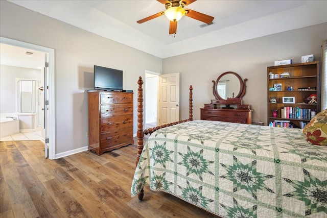 bedroom with light wood-type flooring, visible vents, connected bathroom, and baseboards