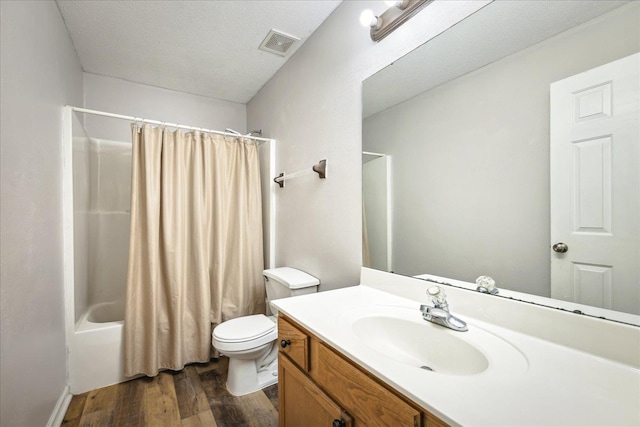 full bath with visible vents, toilet, a textured ceiling, vanity, and wood finished floors