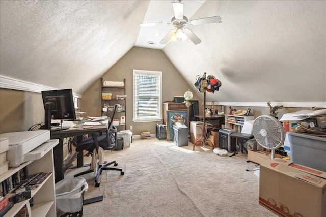 home office with carpet, vaulted ceiling, a textured ceiling, ceiling fan, and baseboards