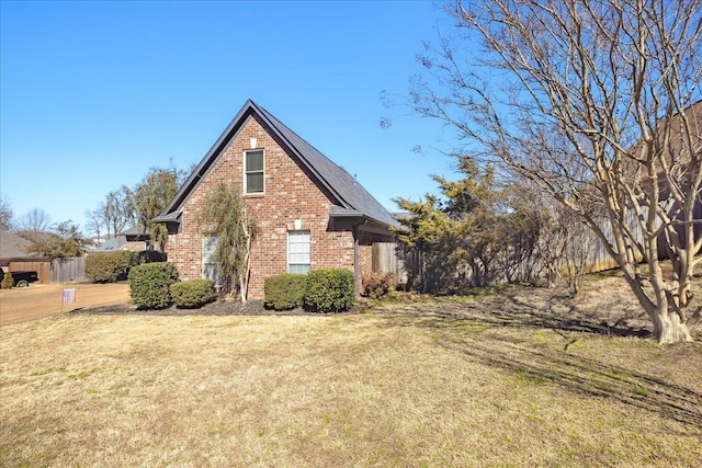 view of side of property with a yard and brick siding