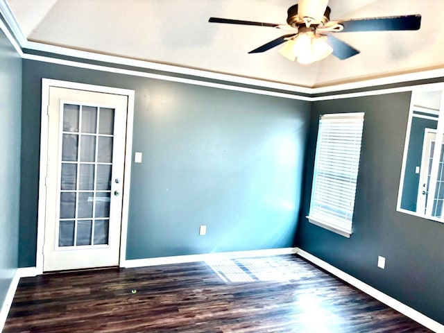 empty room featuring crown molding, wood finished floors, a ceiling fan, and baseboards