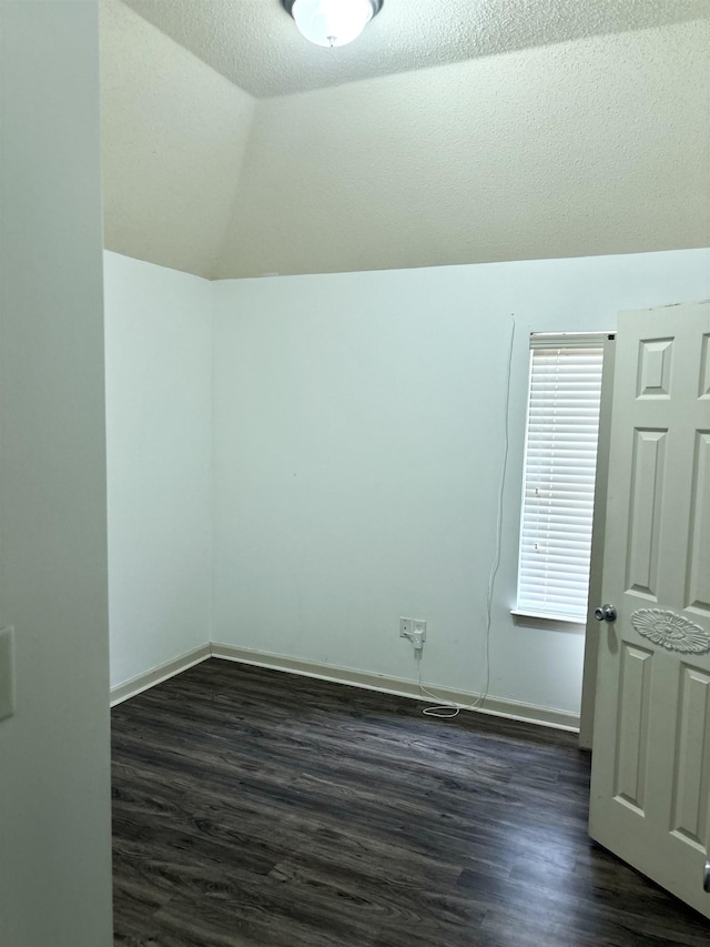 bonus room featuring dark wood-style floors, vaulted ceiling, a textured ceiling, and baseboards