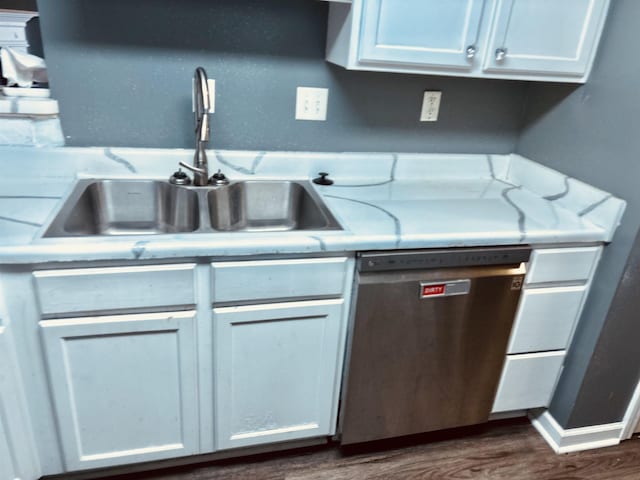 kitchen featuring baseboards, dishwasher, dark wood-type flooring, light countertops, and a sink