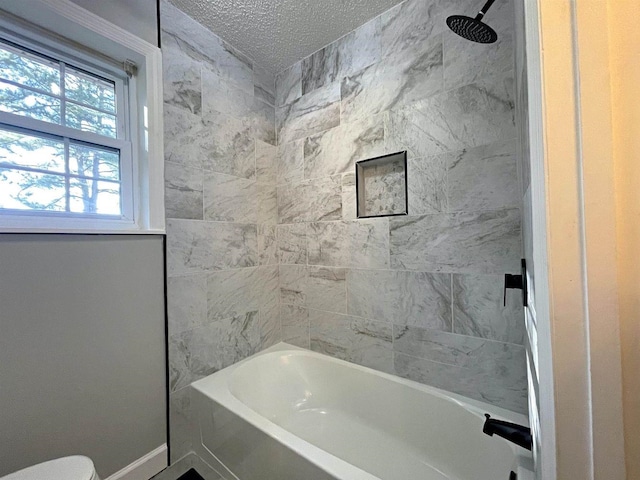 full bath featuring a textured ceiling, shower / washtub combination, and baseboards