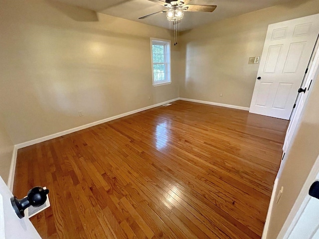 empty room featuring ceiling fan, wood finished floors, and baseboards