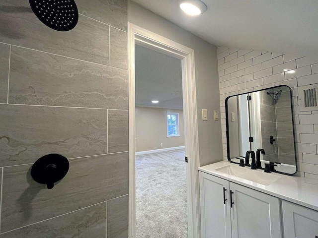 full bath featuring recessed lighting, tiled shower, vanity, and baseboards