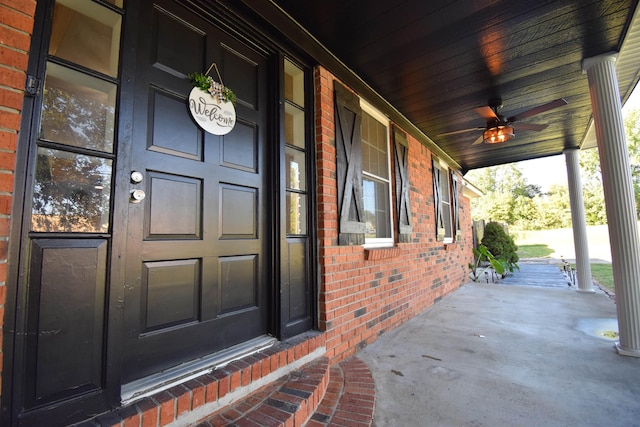 doorway to property with a porch and brick siding