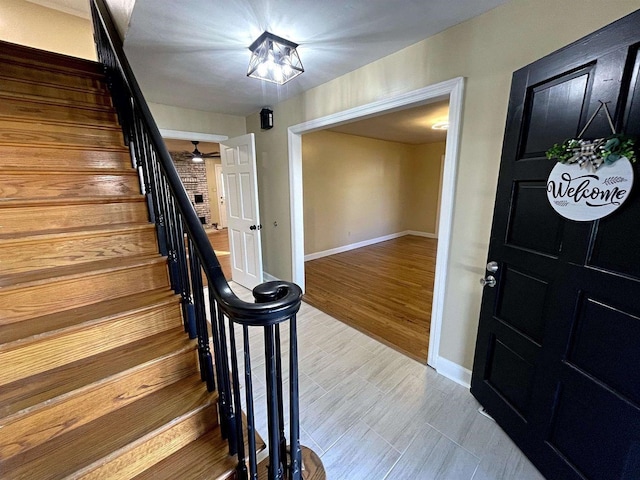 foyer entrance featuring stairs, baseboards, and wood finished floors