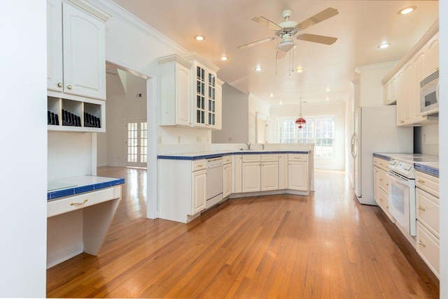 kitchen with a wealth of natural light, white appliances, a sink, and a peninsula