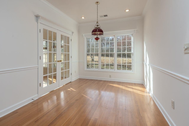 unfurnished dining area with wood-type flooring, visible vents, and crown molding