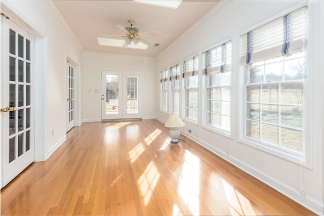 unfurnished sunroom with ceiling fan and french doors