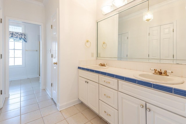 full bath with crown molding, double vanity, a sink, baseboards, and tile patterned floors