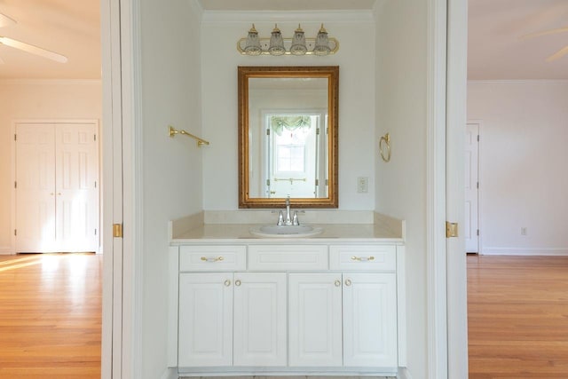 bathroom featuring ornamental molding, vanity, baseboards, and wood finished floors