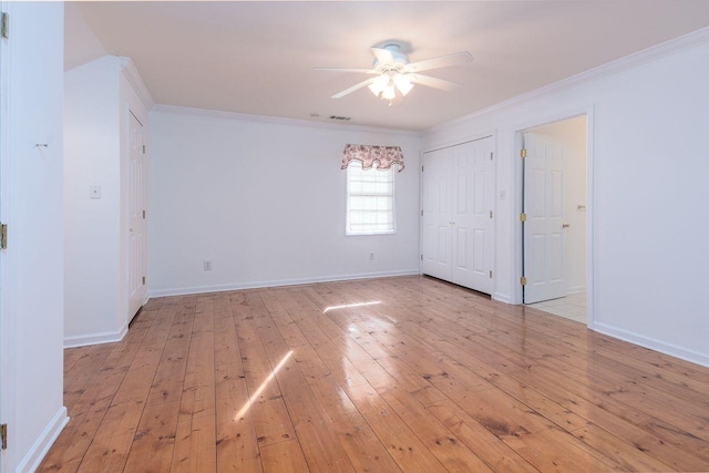 unfurnished room with light wood finished floors, ceiling fan, baseboards, and crown molding