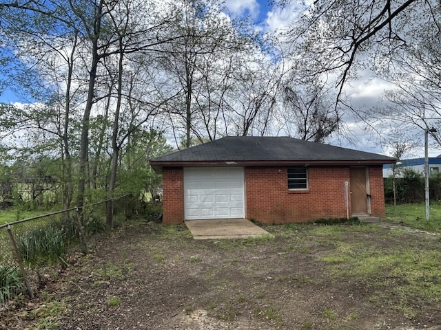 view of outdoor structure with dirt driveway and fence