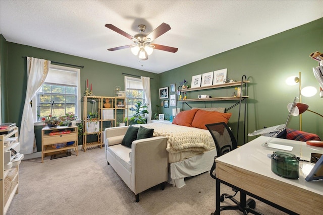 carpeted bedroom with a textured ceiling, ceiling fan, and multiple windows