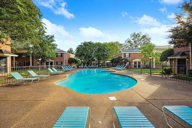 community pool featuring fence and a patio