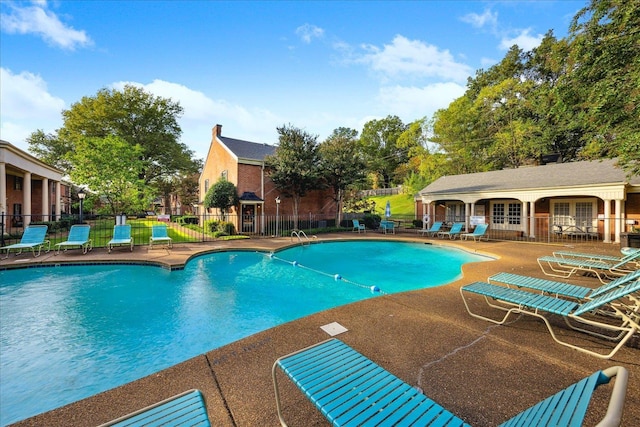 community pool featuring french doors, a patio, and fence