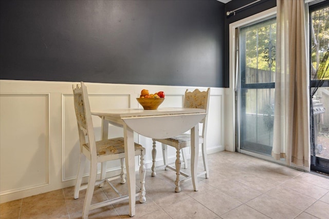 dining room with wainscoting and tile patterned floors