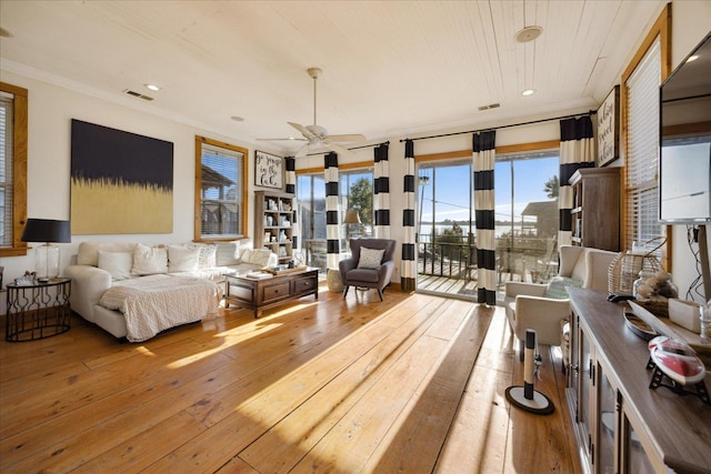 interior space featuring ornamental molding, access to outside, wood-type flooring, and visible vents