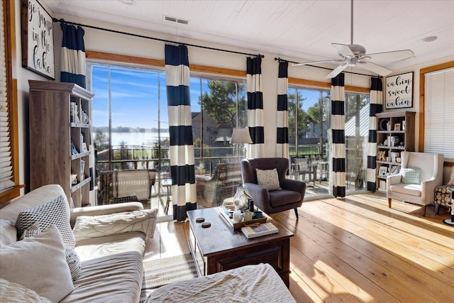 living area featuring wood-type flooring, visible vents, and ceiling fan