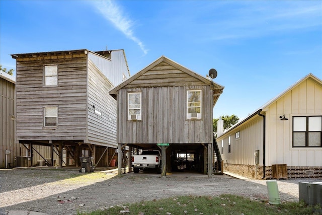 view of front of house with stairs, a carport, driveway, and central air condition unit