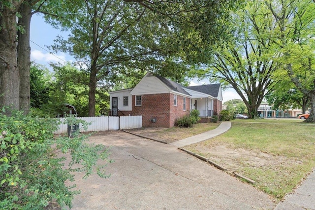 view of home's exterior featuring brick siding, a lawn, crawl space, fence, and driveway