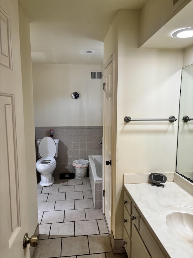 full bathroom with toilet, a bath, tile patterned floors, vanity, and tile walls