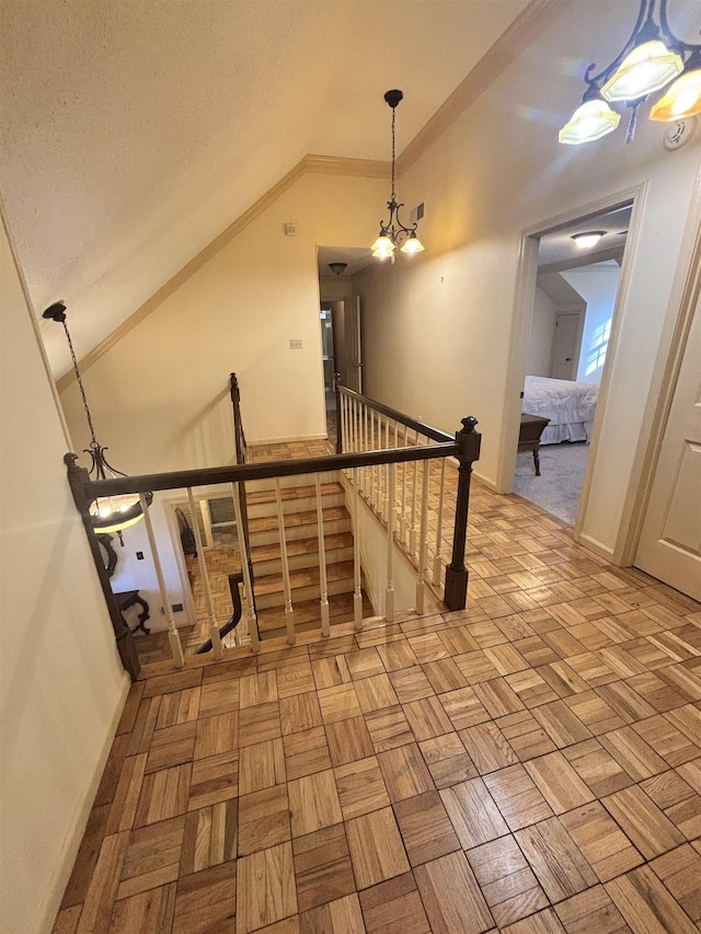 interior space with lofted ceiling, an inviting chandelier, ornamental molding, a textured ceiling, and baseboards