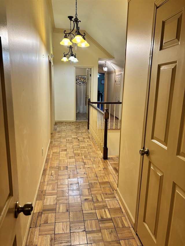 hallway featuring baseboards, a chandelier, an upstairs landing, and crown molding