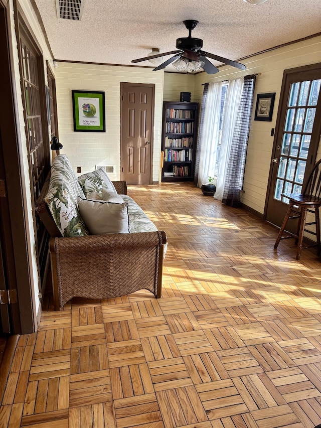 living room with a textured ceiling, plenty of natural light, and visible vents