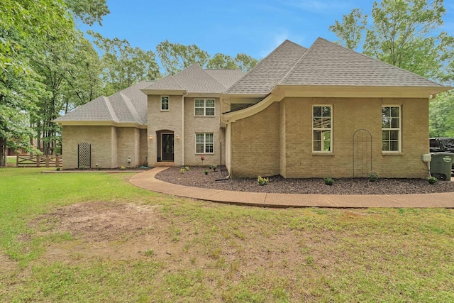 view of front of property featuring a shingled roof, fence, and a front yard