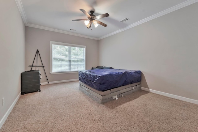 carpeted bedroom featuring baseboards, a ceiling fan, visible vents, and crown molding