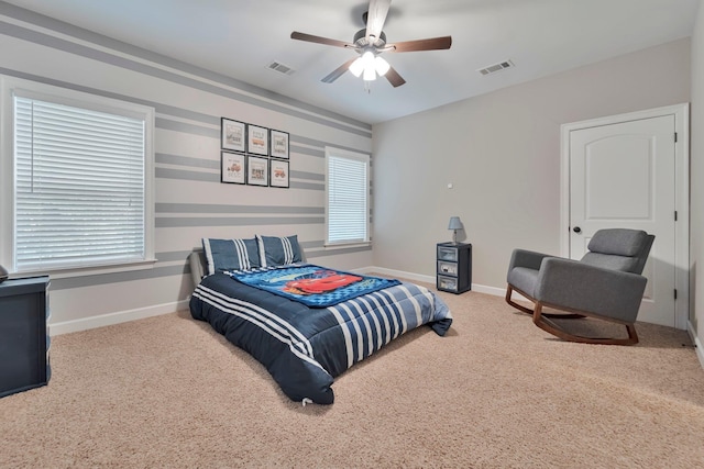 carpeted bedroom with a ceiling fan, visible vents, and baseboards