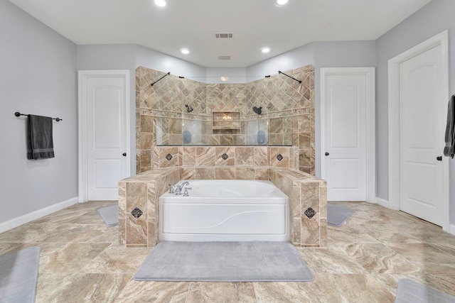 full bathroom with a walk in shower, a garden tub, visible vents, and baseboards