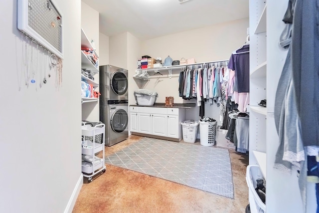 walk in closet featuring stacked washer and dryer and light carpet