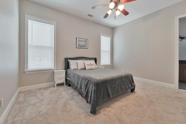 bedroom featuring baseboards, ceiling fan, visible vents, and light colored carpet