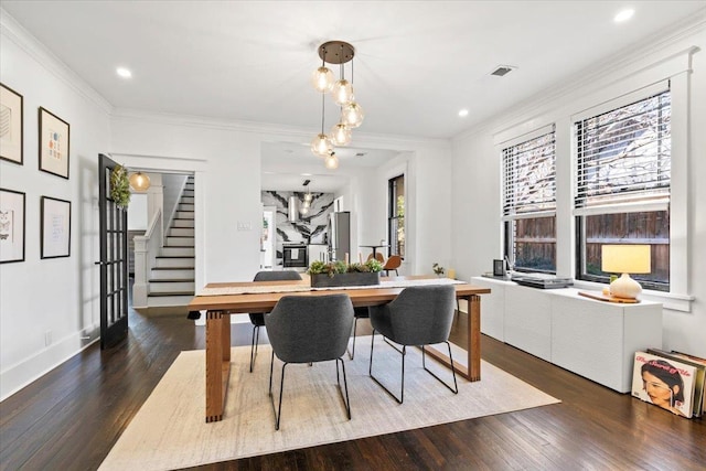 dining room featuring stairs, ornamental molding, and wood finished floors