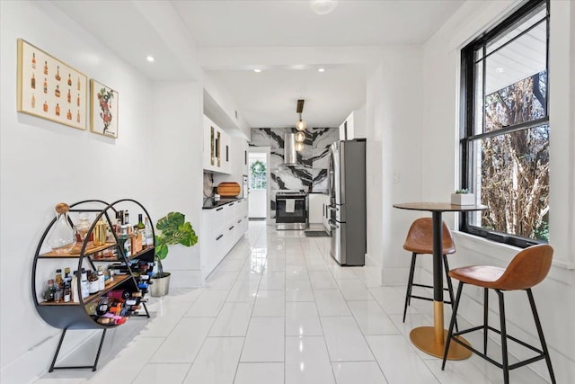 corridor with light tile patterned floors, baseboards, and recessed lighting