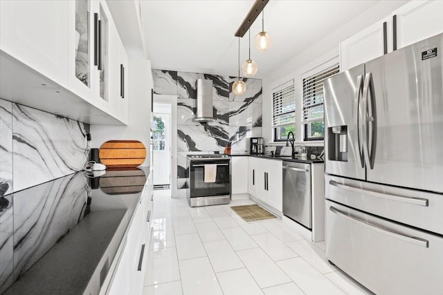 kitchen with stainless steel appliances, a sink, decorative backsplash, wall chimney exhaust hood, and dark countertops