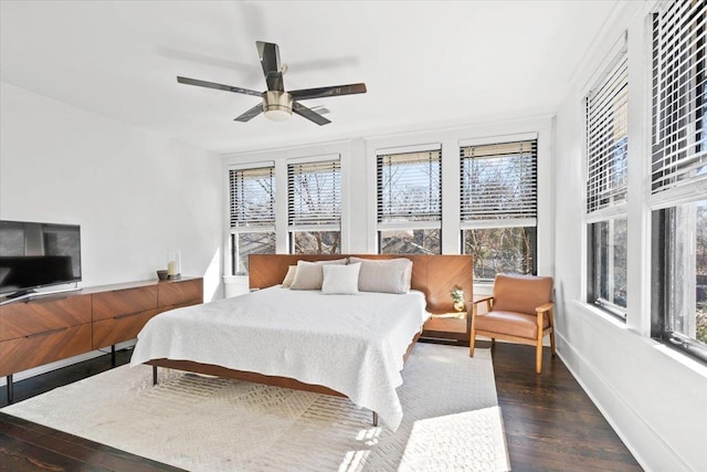 bedroom with ceiling fan, wood finished floors, and baseboards