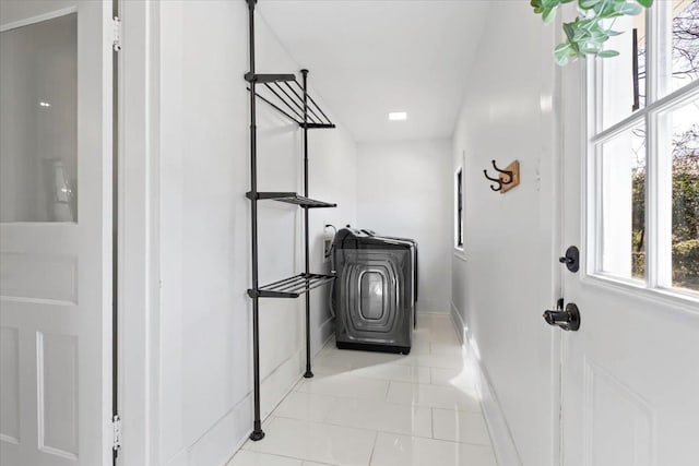 interior space with laundry area, tile patterned flooring, and baseboards