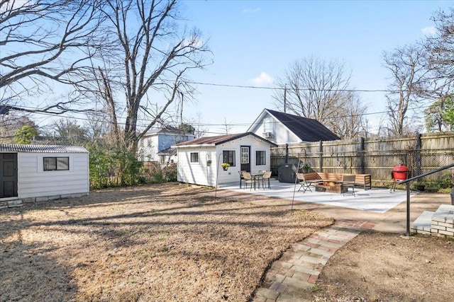 rear view of property featuring fence, a patio, and an outdoor structure