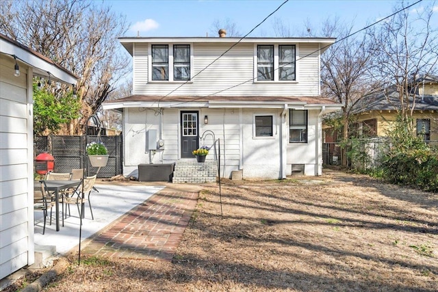 back of property with entry steps, a patio area, and fence