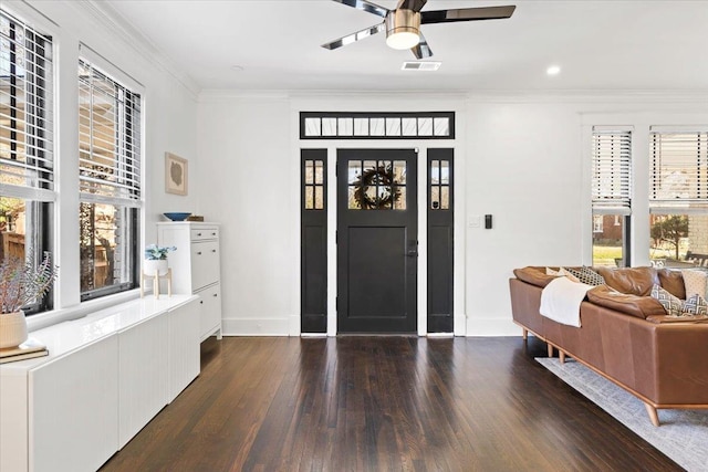 foyer entrance with visible vents, ornamental molding, a ceiling fan, wood finished floors, and baseboards