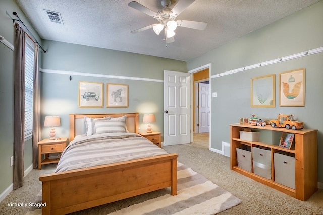 bedroom featuring carpet floors, visible vents, and a textured ceiling